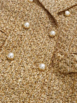 Blazer croisé en tweed doré boutons nacrés taille cintrée longueur midi.