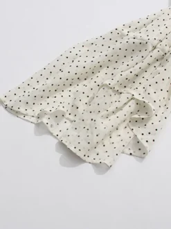 Blouse blanche pour femme col en V manches longues lacées et à volants.