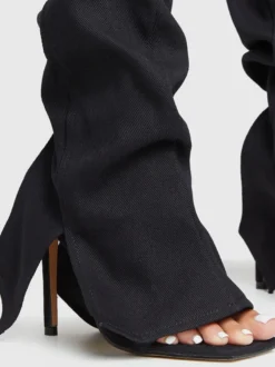 Bottes hautes en denim noir à bout ouvert et découpes à talons hauts.