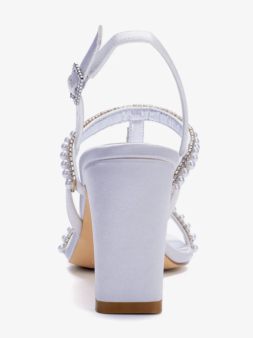 Chaussures de mariée blanches à bout ouvert ornées de perles et à talon compensé en forme de T.