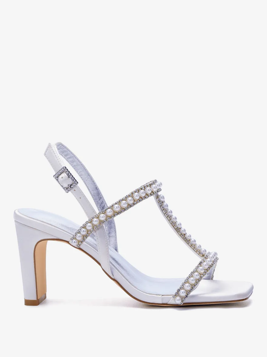 Chaussures de mariée blanches à bout ouvert ornées de perles et à talon compensé en forme de T.