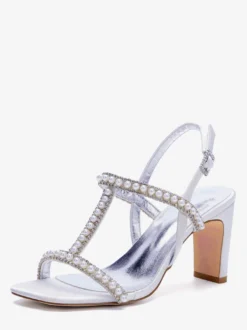 Chaussures de mariée blanches à bout ouvert ornées de perles et à talon compensé en forme de T.