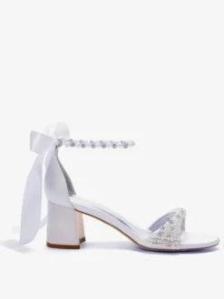 Chaussures de mariée blanches à bout ouvert ornées de perles et de strass avec bride à la cheville et talon compensé.
