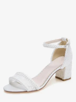 Chaussures de mariée ivoire à bout ouvert et talon compensé ornées de dentelle.