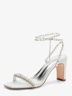 Chaussures de mariée ivoire en satin et perles à bride cheville et talons hauts.