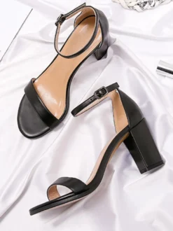 Chaussures noires de soirée à bout ouvert et à boucle à talon épais.