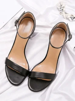 Chaussures noires de soirée à bout ouvert et à boucle à talon épais.