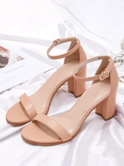 Chaussures noires de soirée à bout ouvert et à boucle à talon épais.