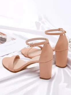 Chaussures noires de soirée à bout ouvert et à boucle à talon épais.