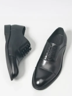 Chaussures Oxford noires à bout rapporté pour hommes en cuir véritable à lacets.