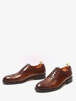 Chaussures Oxford noires à bout rapporté pour hommes en cuir véritable à lacets.