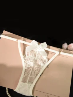 Culotte string en dentelle transparente à gros nœud et fines bretelles latérales