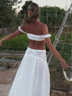 Ensemble deux pièces blanc décontracté avec jupe sans manches sculptante et découpes idéal pour la plage.