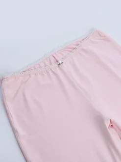 Ensemble deux pièces rose en dentelle : haut bustier sans bretelles legging capri taille haute et bordure en dentelle.