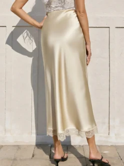 Jupe longue élégante de printemps en satin blanc écru taille naturelle pour femme.