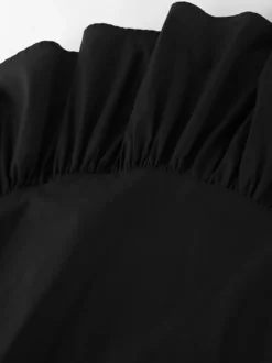 Jupe noire asymétrique mi-longue à volants et taille haute
