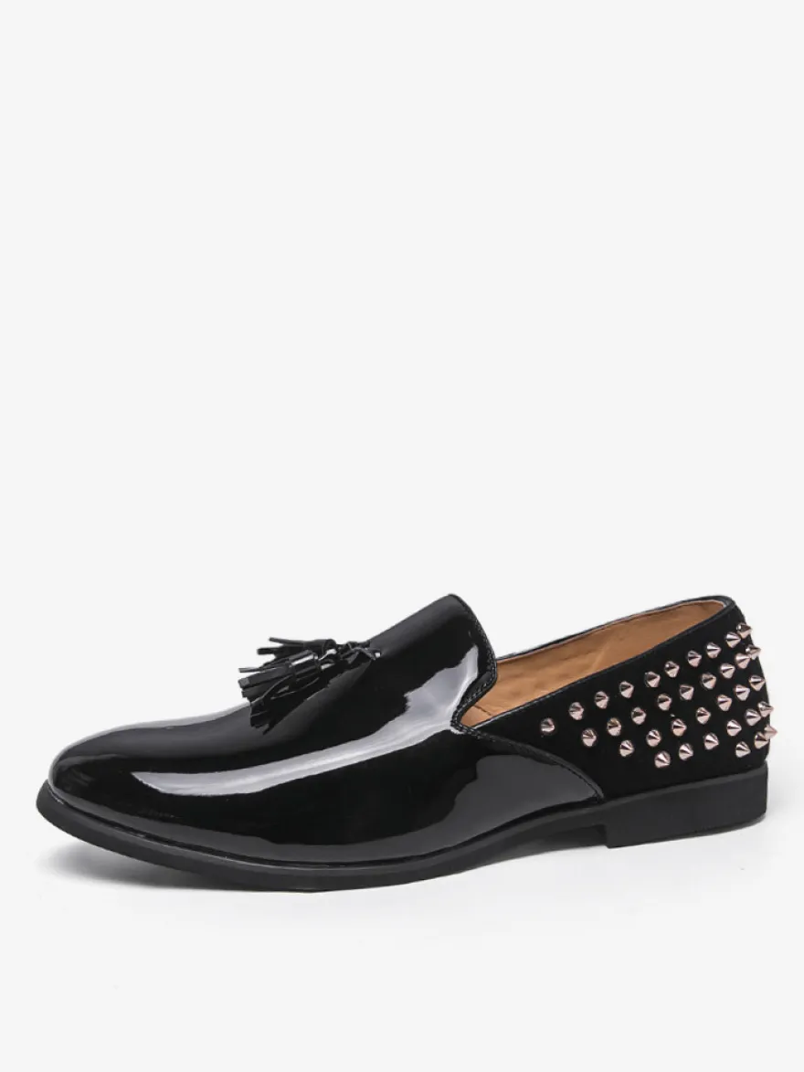 Mocassins noirs à bout rond pour homme ornés de rivets et de pompons.