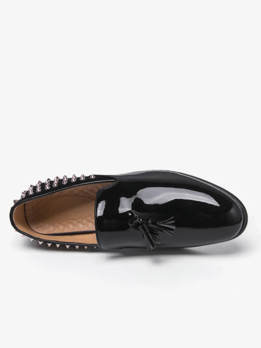 Mocassins noirs à bout rond pour homme ornés de rivets et de pompons.
