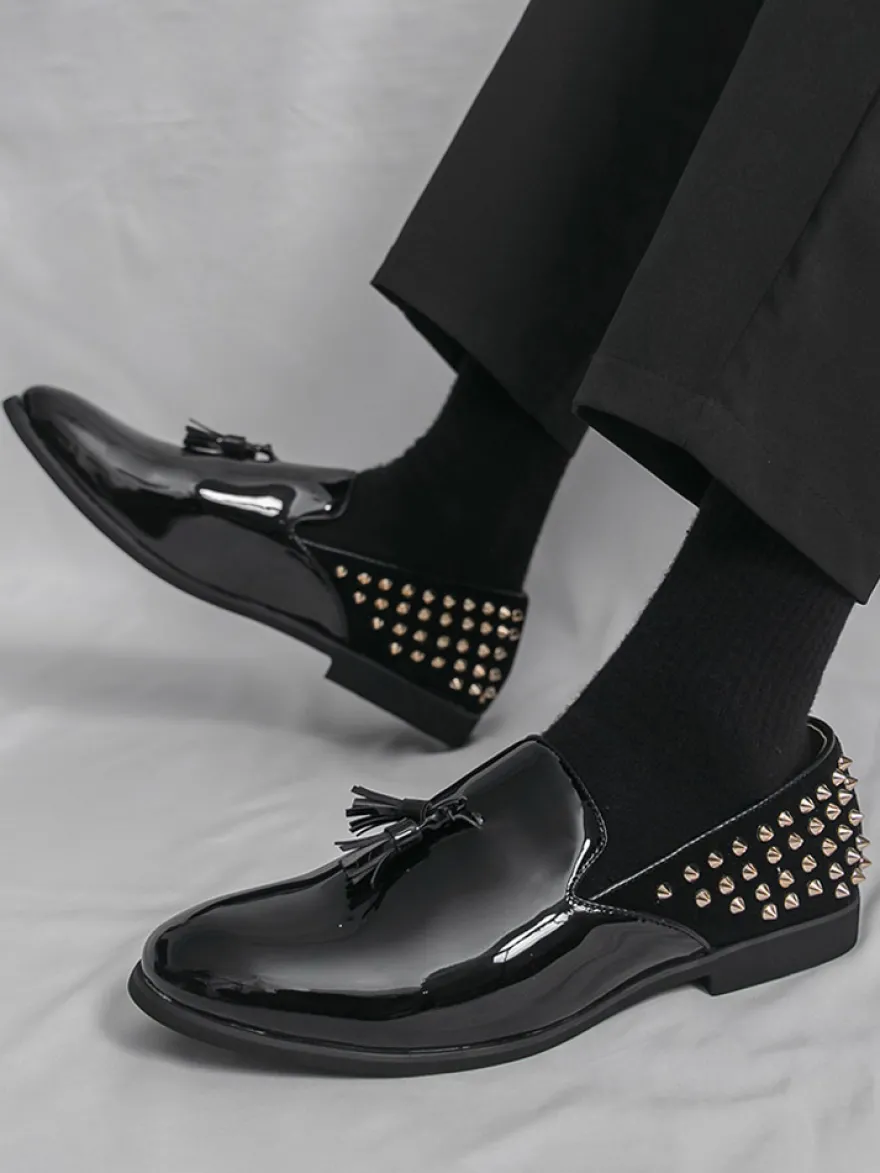 Mocassins noirs à bout rond pour homme ornés de rivets et de pompons.