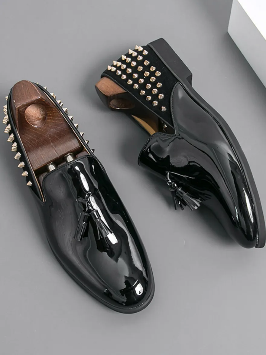 Mocassins noirs à bout rond pour homme ornés de rivets et de pompons.
