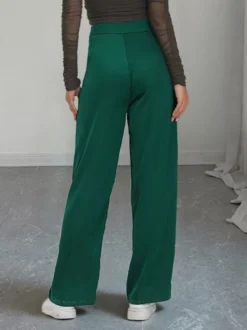 Pantalon de costume taille haute à double boutonnage et jambes larges coupe drapée.