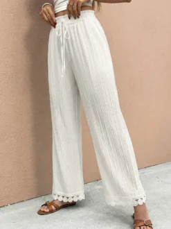 Pantalon large à ourlet en dentelle blanche et cordon de serrage coupe ample et décontractée idéal pour l'été.