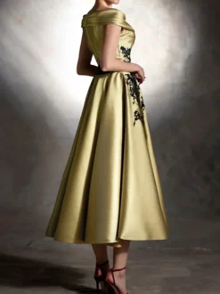 Robe de bal en satin décolleté travaillé manches courtes ornée d'appliqués