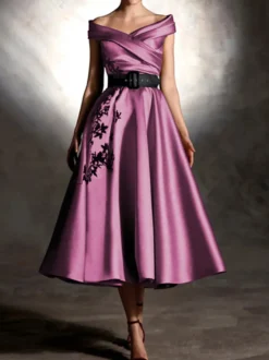 Robe de bal en satin décolleté travaillé manches courtes ornée d'appliqués