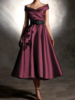 Robe de bal en satin décolleté travaillé manches courtes ornée d'appliqués
