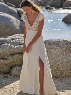 Robe de mariée bohème en crêpe stretch et dentelle coupe trapèze avec traîne taille naturelle fermeture éclair manches courtes col en V blanche