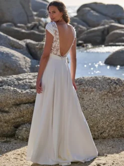 Robe de mariée bohème en crêpe stretch et dentelle coupe trapèze avec traîne taille naturelle fermeture éclair manches courtes col en V blanche
