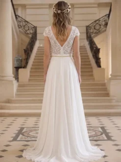 Robe de mariée bohème en dentelle et mousseline coupe trapèze taille naturelle fermeture éclair manches courtes col en V idéale pour un mariage à la mairie.
