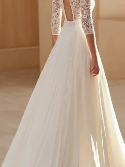 Robe de mariée bohème en mousseline découpée coupe trapèze avec traîne taille naturelle dos nu manches 3/4 col carré couleur ivoire