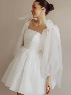 Robe de mariée courte bustier manches longues coupe princesse taille naturelle en organza