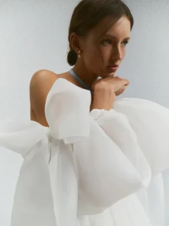 Robe de mariée courte bustier manches longues coupe princesse taille naturelle en organza