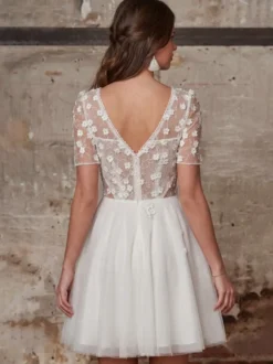 Robe de mariée courte en dentelle pour mariage civil col en V manches courtes coupe trapèze.