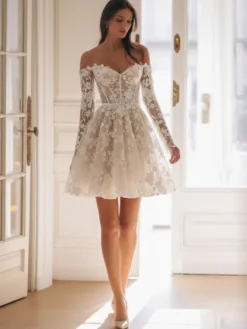 Robe de mariée courte en tulle décolleté en cœur manches 3/4 taille naturelle.