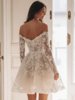 Robe de mariée courte en tulle décolleté en cœur manches 3/4 taille naturelle.