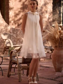 Robe de mariée courte longueur genou col bijou sans manches coupe trapèze taille naturelle en mousseline