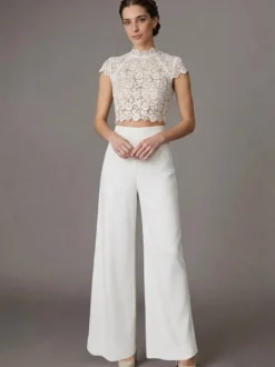 Robe de mariée deux pièces en crêpe stretch décolleté travaillé longueur au sol fermeture éclair manches courtes.