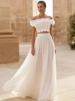 Robe de mariée deux pièces en mousseline col bateau longueur au sol boutons fonctionnels manches courtes.