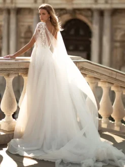 Robe de mariée en dentelle col V boutonné sur dos pélerine amovible jupe fendue au sol