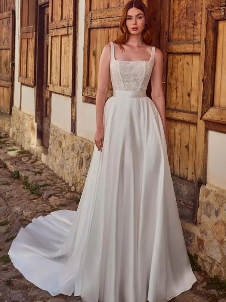 Robe de mariée vintage deux pièces courte en satin et dentelle coupe trapèze sans manches longue.