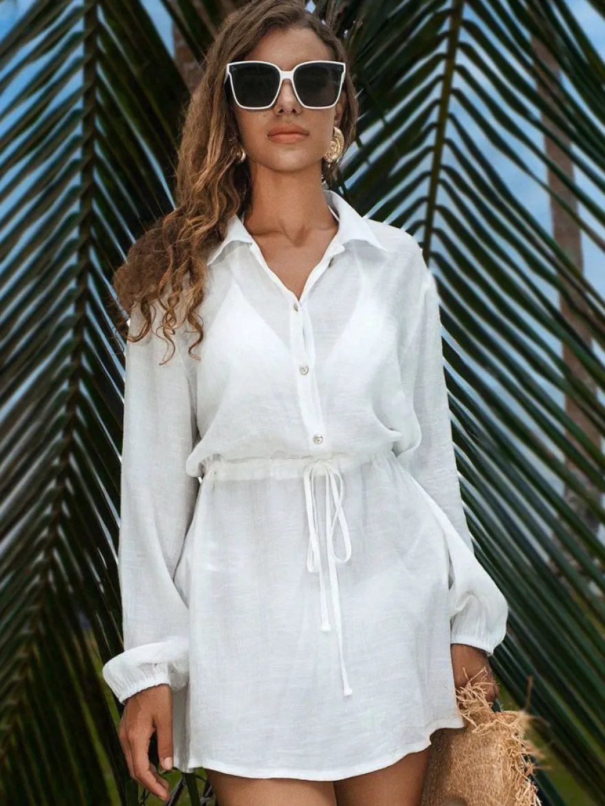 Robe de vacances blanche chic à boutons cintrants manches longues et col rabattu.