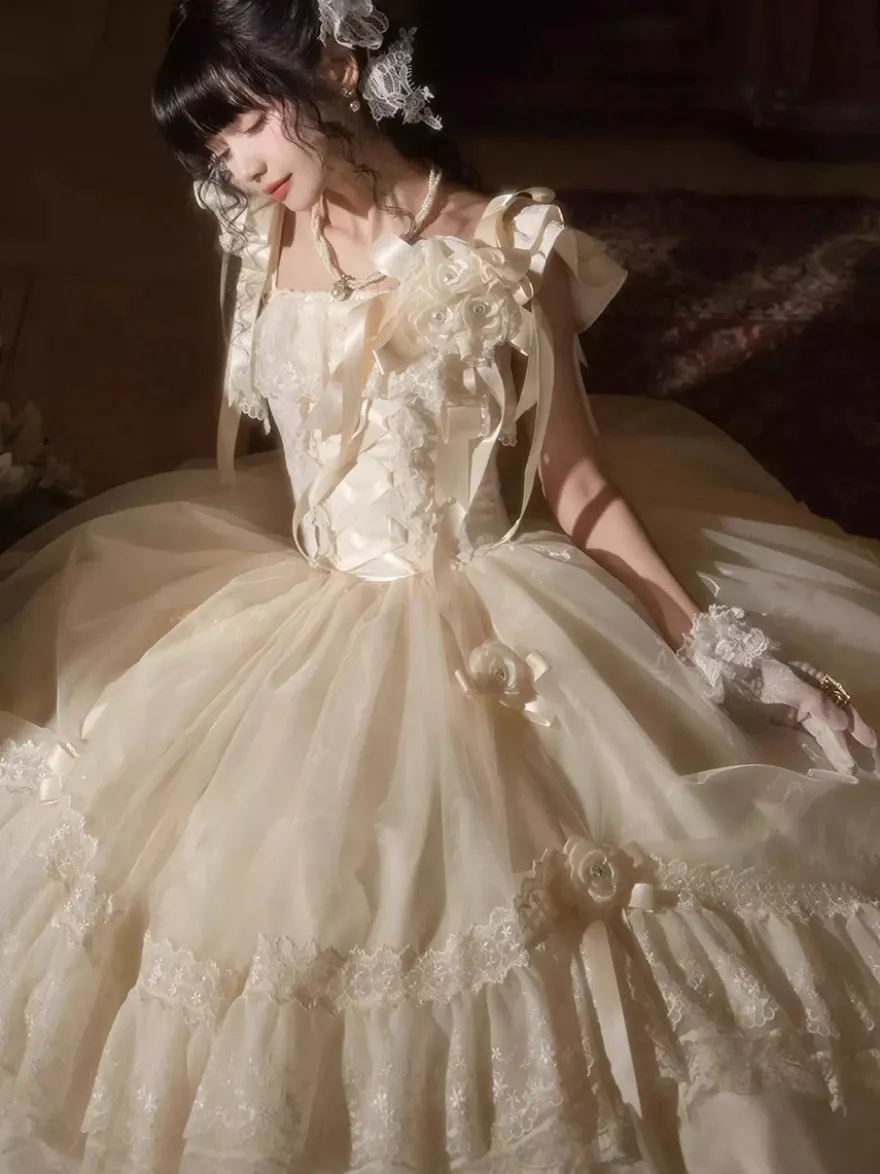 Robe longue Lolita fée blanche à lacets et nœuds ornée de fleurs idéale pour un goûter.