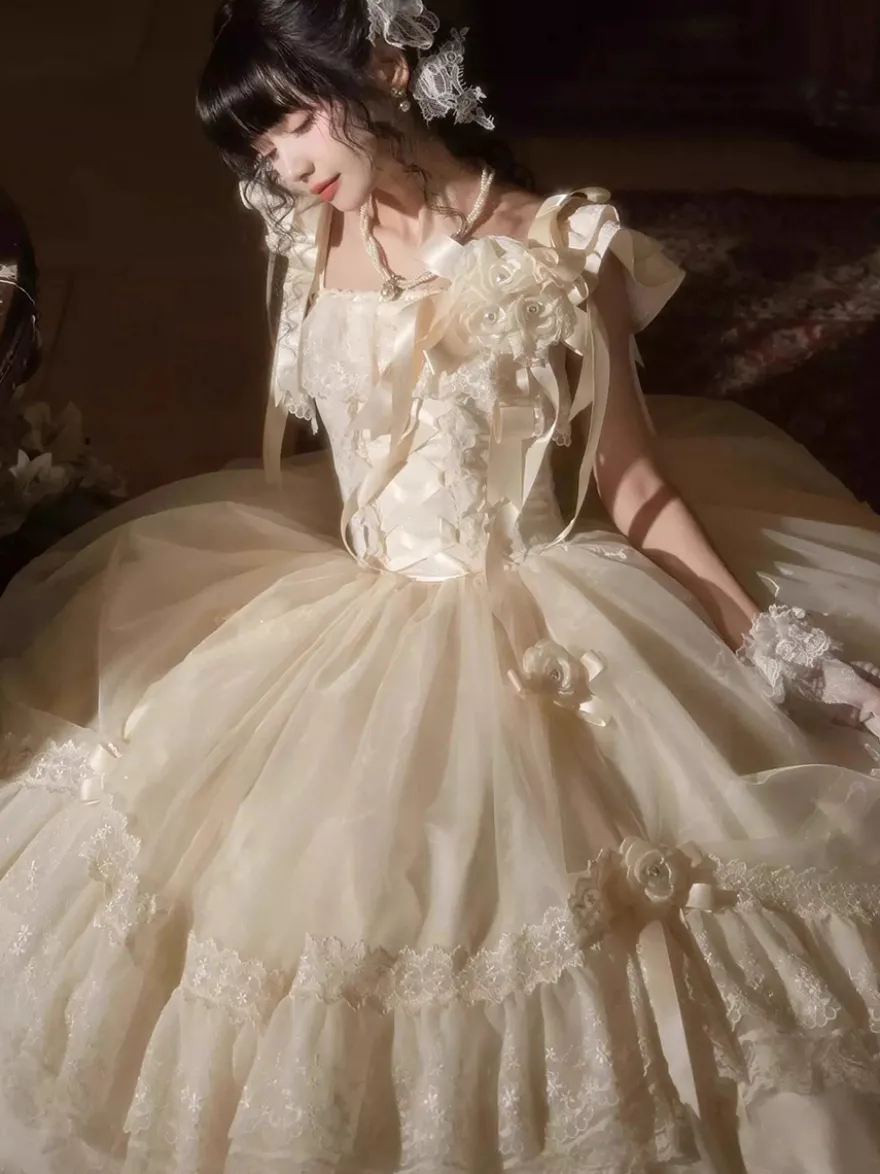 Robe longue Lolita fée blanche à lacets et nœuds ornée de fleurs idéale pour un goûter.