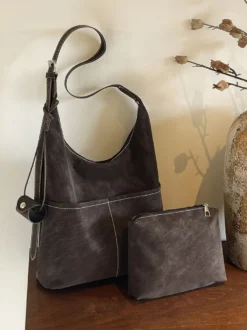 Sac hobo vintage en daim avec surpiqûres contrastées bandoulière ajustable et porte-monnaie intégré.