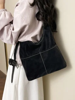 Sac hobo vintage en daim avec surpiqûres contrastées bandoulière ajustable et porte-monnaie intégré.