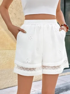 Short blanc pour femme à taille élastique avec broderie florale et bordure en dentelle coupe ample idéal pour l'été.
