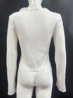 Top en maille côtelée à col en V et manches cloche orné de dentelle collection femme 2026
